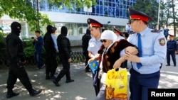 Полиция қарт адамды ұстап әкетіп барады. Алматы, 21 мамыр 2016 жыл. (Көрнекі сурет)
