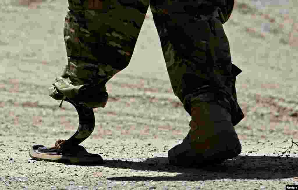 A NATO soldier walks with an artificial limb to board a Chinook helicopter after a security handover ceremony at a military academy outside Kabul. (Reuters/Omar Sobhani)