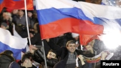 Simpatizues të Vlladimir Putinit duke festuar fitoren në sheshin Manezh të Moskës.