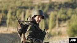 A Turkish soldier sits on a road in the province of Sirnak, near the Turkish-Iraqi border