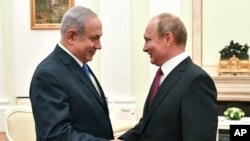 Russian President Vladimir Putin, right, shakes hands with Israeli Prime Minister Benjamin Netanyahu during their meeting at the Kremlin in Moscow, Wednesday, July 11, 2018. (Yuri Kadobnov/ Pool photo via AP)