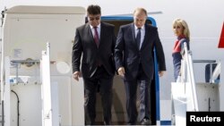 Russia's ambassador to Finland, Pavel Kuznetsov (left), welcomes Russian President Vladimir Putin as he arrives at Helsinki Airport in 2018.
