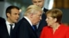 U.S. President Donald Trump (C) walks past French President Emmanuel Macron (L) and German Chancellor Angela Merkel on his way to his spot for a family photo during the NATO summit at their new headquarters in Brussels, May 25, 2017