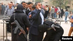 Syria -- Fighters from the Islamist Syrian rebel group Jabhat al-Nusra search civilians at the Karaj al-Hajez crossing, a passageway separating Aleppo's Bustan al-Qasr, which is under the rebels' control, and Al-Masharqa neighborhoods, an area controlled