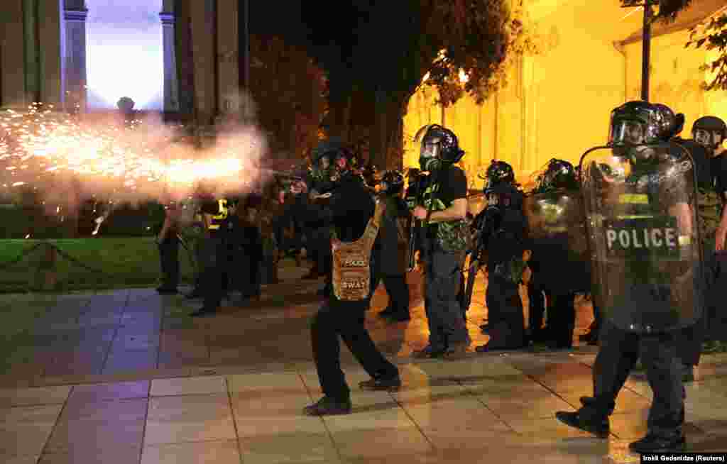 Riot police fire a projectile near the parliament. 