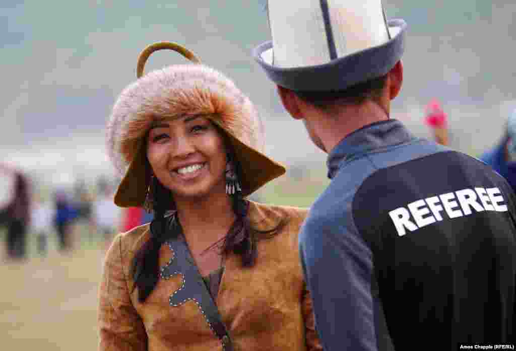 Kyrgyz archer Aida Akhmatova flashes a smile as she speaks with a referee during an event.