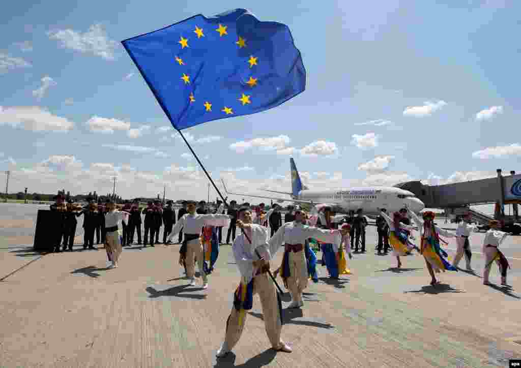 A troupe of Ukrainian dancers performs on the tarmac at Boryspil airport in Kyiv on June 11, the first day of visa-free travel for Ukrainian nationals to the European Union. (epa/Stepan Franko)