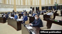 Участники заседания в сенате парламента Казахстана в защитных масках.