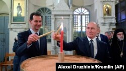 ფოტო არქივიდან. ბაშარ ასადი (მარცხნივ) და ვლადიმირ პუტინი სირიაში, მართლმადიდებლურ ტაძარში. 2020 წლის 7 იანვარი