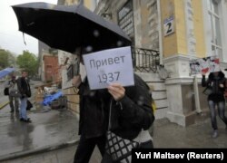 Учасники протесту проти режиму Володимира Путіна прогулюються з плакатами. Напис на плакаті «Привіт 1937 рік» нагадує про смертельний рік репресій радянського диктатора Йосипа Сталіна. Владивосток, 12 червня 2012 року
