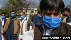 Drivers who work for a Pakistan-based Chinese company wear protective face masks before a check of their temperatures in Islamabad.