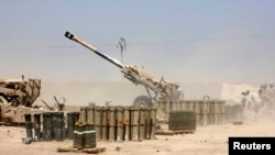 Iraqi security forces fire artillery during clashes with Sunni militants of the Islamic State of Iraq and the Levant (ISIL) on the outskirts of the town of Udaim in Diyala Province on June 22.