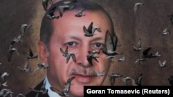Hulubi zburând prin fața unui poster cu Tayyip Erdogan, la Bursa