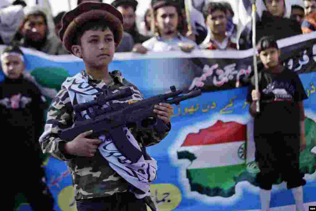 A child supporter of the banned Pakistan-based charity Jamaat-ud-Dawa holds a toy gun during a rally in the Pakistani city of Peshawar expressing solidarity with Kashmiris living in Indian Kashmir. (epa/Arshad Arbab)