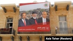 LEBANON -- A poster of Samir Geagea, leader of the Christian Lebanese Forces, former Lebanon's Christian Maronite Patriarch Mar-Nasrallah Boutros Sfeir and Lebanese parliament candidate Georges Aqeis hangs on a building in the city of Zahle, May 4, 2018