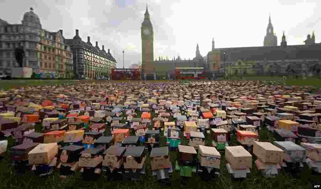 Thousands of personalized cardboard characters lie outside the buildings of the British Parliament in London during a Fairtrade Foundation photocall to encourage government policy to support the world&#39;s smallholder farmers. (AFP/Andrew Cowie)
