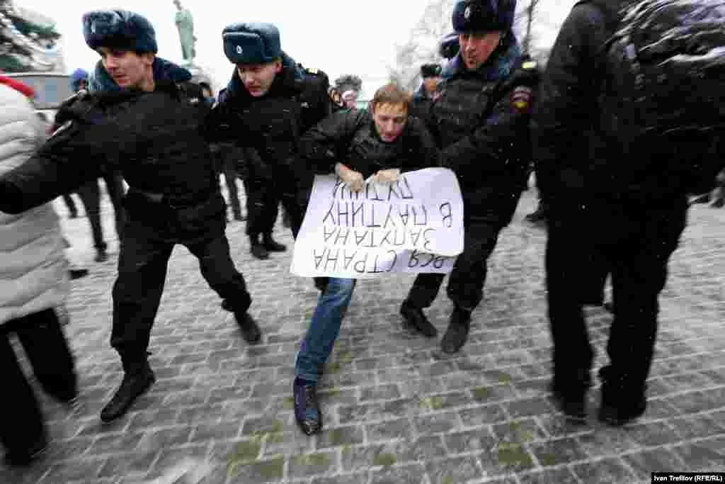 Задержание активиста на Пушкинской площади Москвы. В руках у него плакат &quot;Вся страна запутана в паутину Путина&quot;