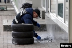 A police expert examines the remnants of the bomb.