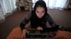 A woman browses on a computer at a women-only Internet cafe in Kabul.