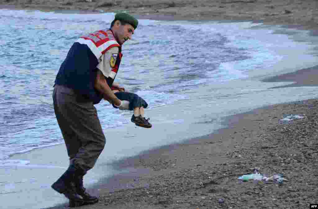 Turski policajac nosi tijelo Ajlana Kurdija nakon što je morska struja izbacila njegovo tijelo.