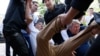 Сотрудники полиции тащат мужчину, который оказался на перекрестке, обозначенном запрещенным в стране движением ДВК как место проведения митинга. Алматы, 23 июня 2018 года.