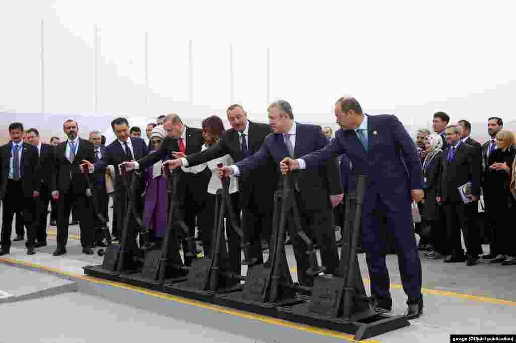 ГРУЗИЈА - Грузискиот премиер Гиорги Квирикашвили, азербејџанскиот претседател Илхам Алиев, турскиот претседател Реџеп Таип Ердоган и казахстанскиот претседател Бакистан Сигинатиев влечат железнички рачки како свртничари на шини во Азербејџан. Тие симболично ја пуштија во употреба новата регионална железничка линија Баку - Тбилиси - Карс.