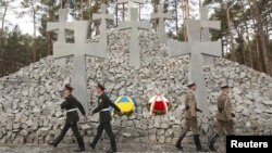 Polish and Ukrainian soldiers march during a commemoration ceremony for the victims of Soviet-era repressions at the memorial near the village of Bykivnia, outside Kyiv, on September 21.