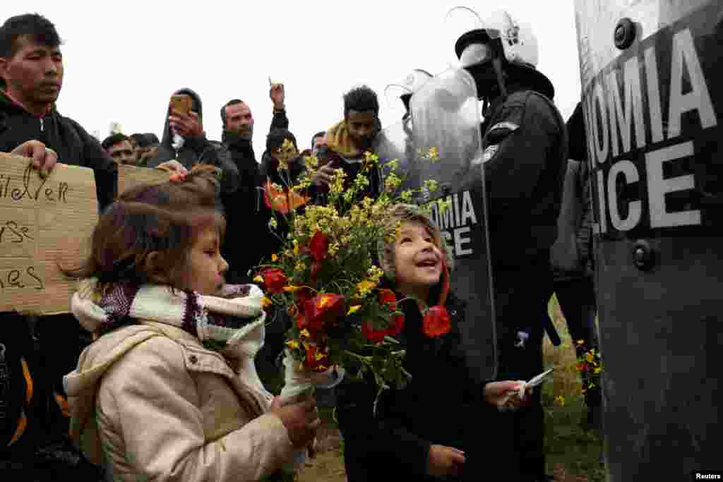 Діти мігрантів дарують квіти співробітникам поліції біля табору &laquo;Діавата&raquo; на півночі Греції, де відбулися сутички.