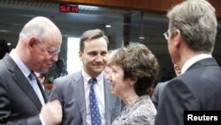 EU foreign policy chief Catherine Ashton (second from right) talks with Dutch Foreign Minister Uri Rosenthal (left), Polish Foreign Minister Radoslaw Sikorski (second from left), and German Foreign Minister Guido Westerwelle in Brussels on March 21.