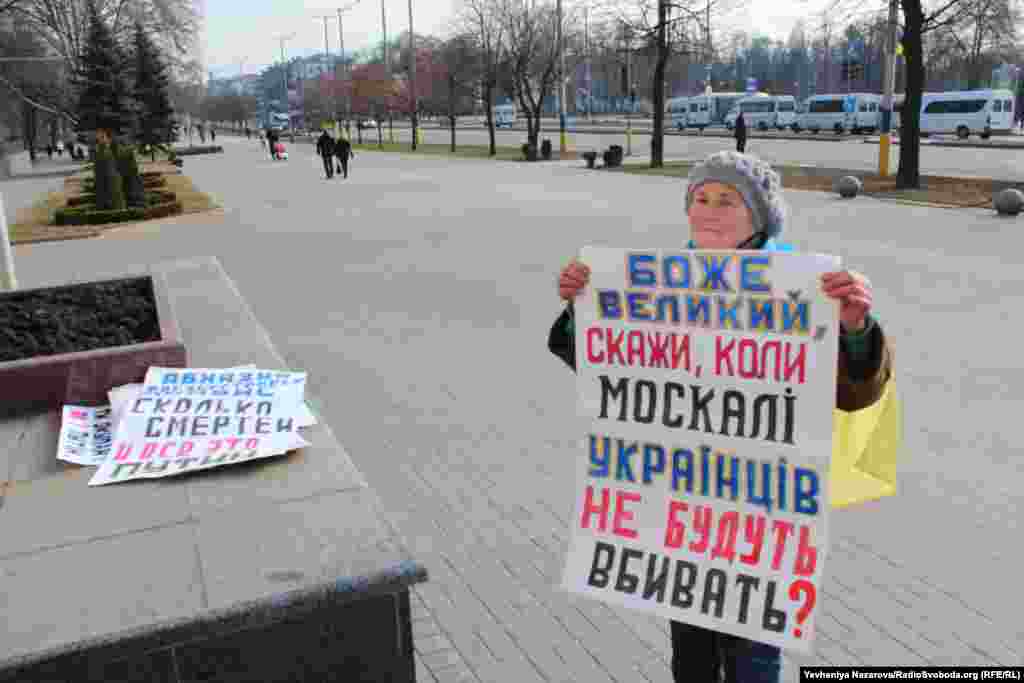 Запорізька активістка демонтує плакати, які принесли &nbsp;під міську раду на знак протесту проти проведення у місті акції на захист пам&#39;ятника Леніну