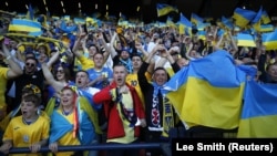 Ukraine fans celebrate their first goal in the play-off semifinal of the UEFA World Cup Qualifiers in Glasgow, Scotland, on June 1. 