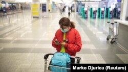 A passenger checks her mobile phone as Serbia halts all commercial flights from Belgrade's airport to prevent the spread of coronavirus on March 19.