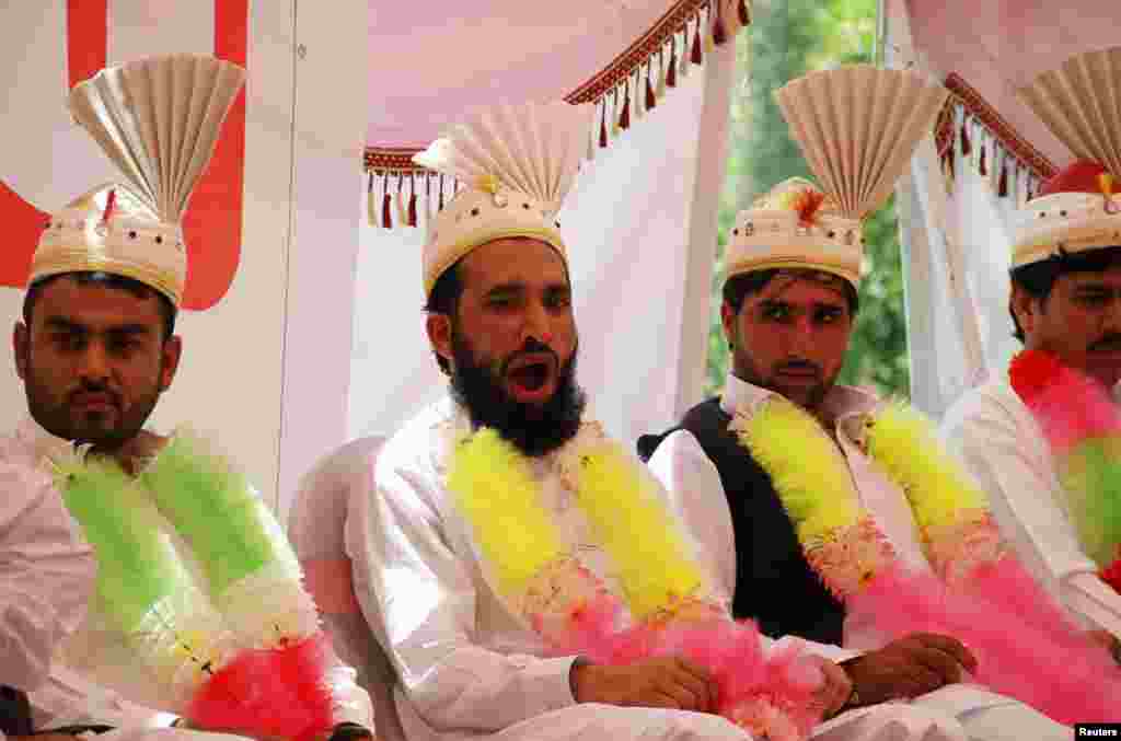 A groom yawns as he sits with others during a mass wedding ceremony in Peshawar, Pakistan. (Reuters/Fayaz Aziz)