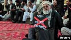 A journalist holds a placard while taking part in a demonstration in front of the Pakistani parliament building in Islamabad on January 28 to highlight the plight of his colleagues.