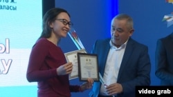 Продюсер проекта «Не от нашего имени» Жулдыз Толеуова и директор казахстанского Национального центра исследования проблем журналистики Сагатбек Медеубеков на вручении диплома. Алматы, 27 ноября 2018 года. 