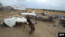 A man walks past the wreckage of the Bhoja Air Boeing 737 at the scene of the crash on the outskirts of Islamabad.