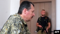 Self-proclaimed defense minister of the pro-Russian separatist "Donetsk People's Republic" Igor Strelkov (left) delivers a press conference as a fellow fighter looks on in Donetsk in July.