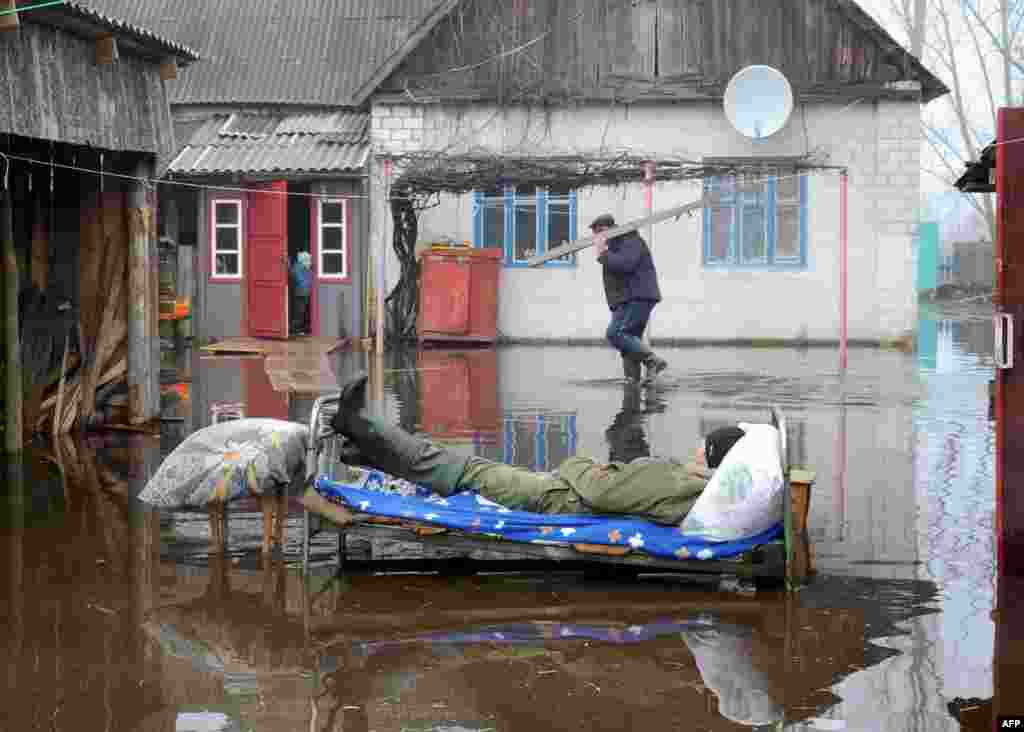 A man rests outdoor during spring floods in the Belarusian village of Khvoensk. (AFP/Viktor Drachev)