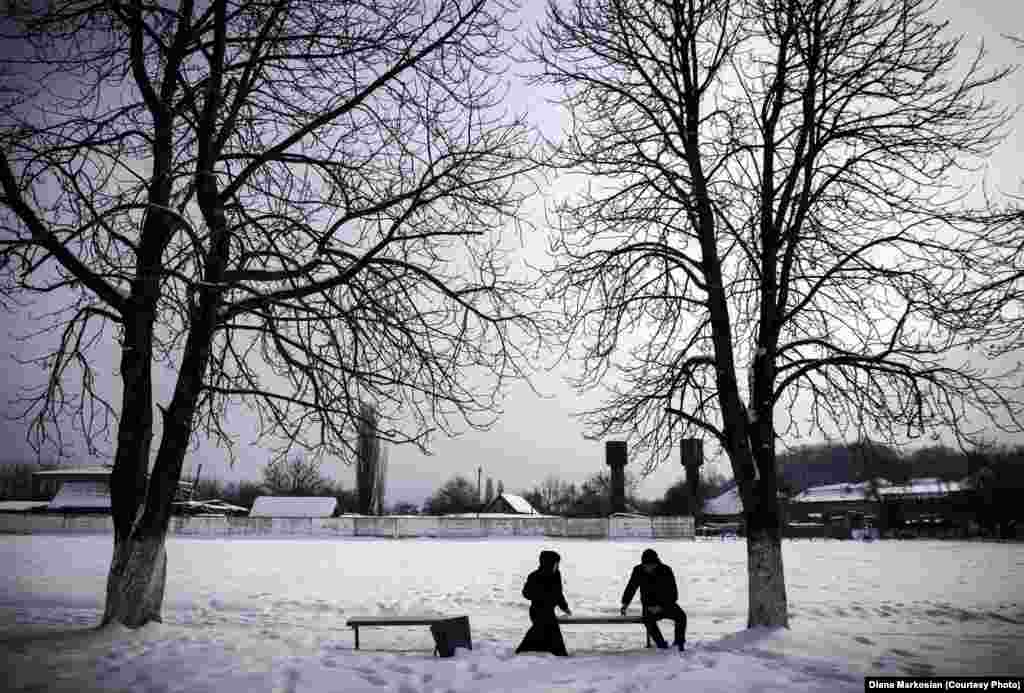 A couple on a date in the village of Serzhen-Yurt. Couples must meet in public and sit apart from one another. All physical contact is forbidden before marriage. 