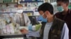 FILE: Afghans buy protective masks after first positive case of coronavirus was reported near the Iranian border in the western city of Herat in February.