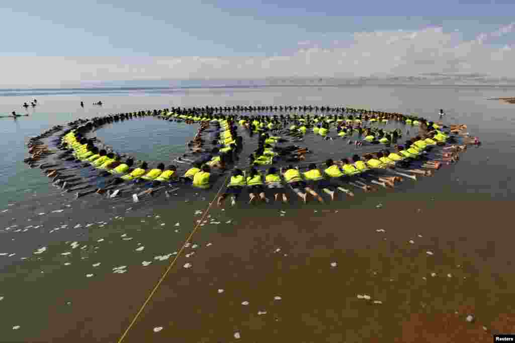 Employees and management of hotels near the Dead Sea form a floating image at the Dead Sea beach, linking up to form a huge peace sign. (Reuters/Muhammad Hamed)