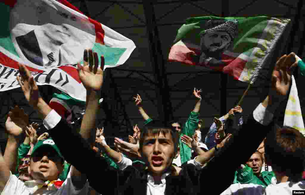 Fans cheer for the Terek Grozny soccer team at a match against Amkar Perm at the Akhmad Arena.