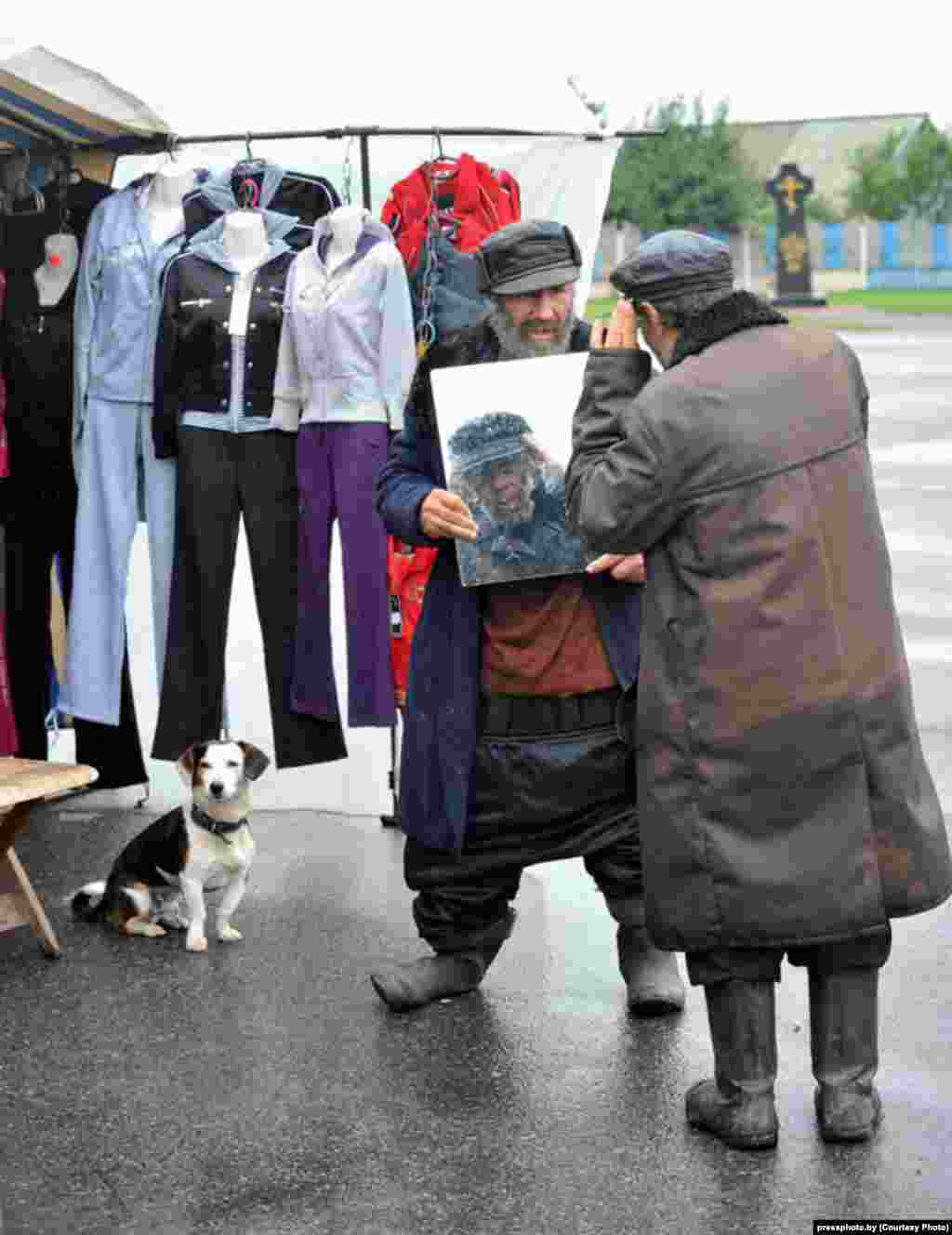 Two people try on hats at a street market in the village of Khvayensk, about 270 kilometers south of Minsk. Photograph by Viktar Drachou