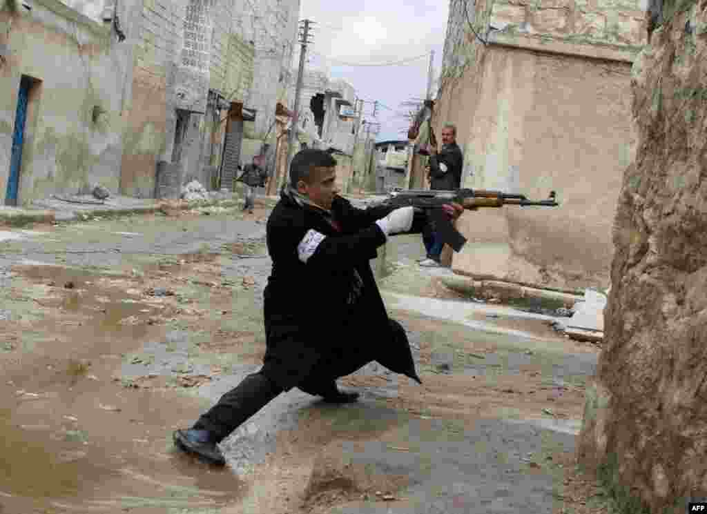 A rebel aims his weapon during clashes with Syrian government forces in the streets near Aleppo International Airport. (AFP/Stephen J. Boitano)
