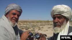 Two Afghan men receive solar-powered radios from Radio Azadi. (09Oct2010)