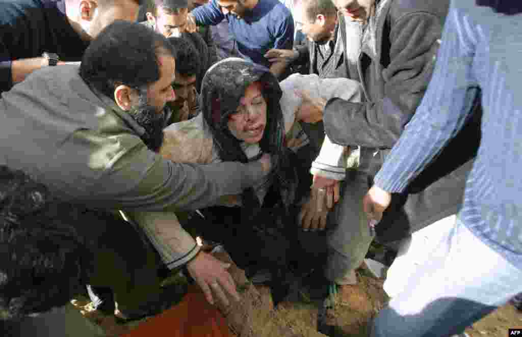 Палестинцы помогают раненной женщине, Газа, 28 декабря 2008.