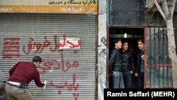 Police sealing a store which allegedly distributed drugs in the city of Mashhad, on March 15, 2017.