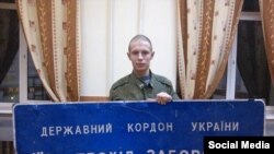 Российский военнослужащий с табличкой погранслужбы Украины. 