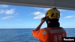 Афіцэр патрульнага карабля берагавой аховы Тайваня назірае за караблём берагавой аховы Кітая на паўночны захад ад вострава Пэнцзя, на гэтым здымку, апублікаваным 29 сьнежня 2025 