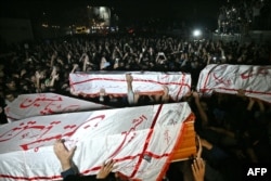 Шиїтські мусульмани несуть труни протестувальників, які загинули під час демонстрації біля консульства США в Карачі, Пакистан, 1 березня 2026 року після смерті верховного лідера Ірану аятоли Алі Хаменеї